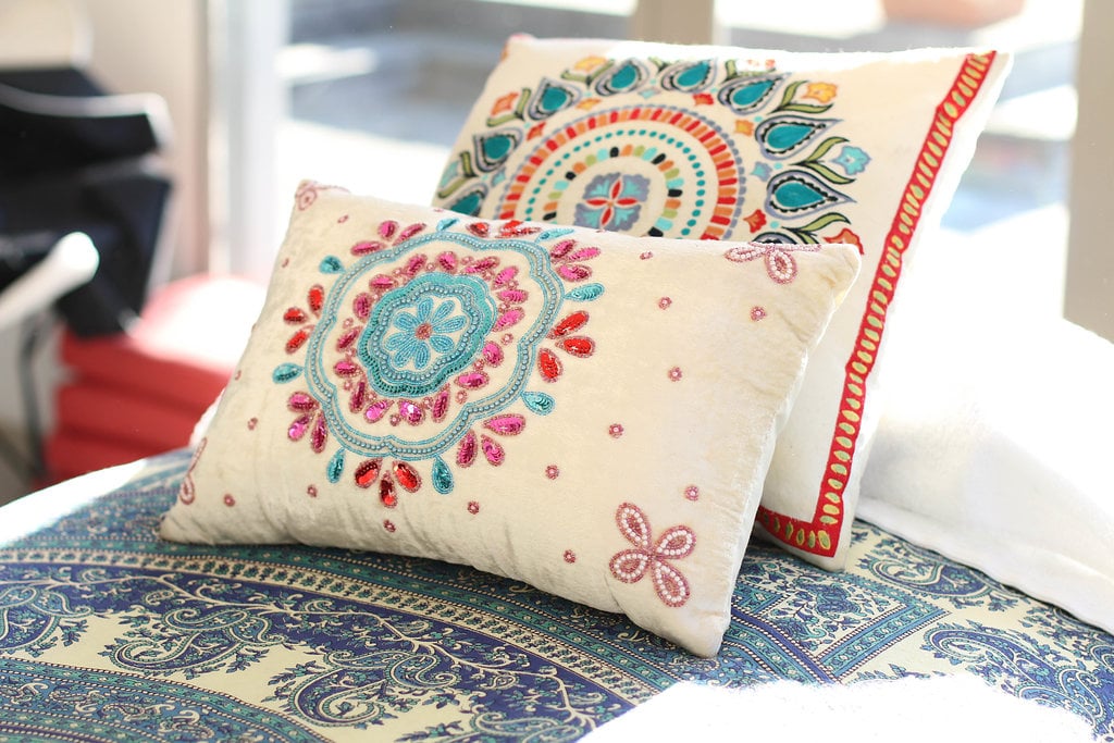 Embroidered cushions on a paisley throw by a window