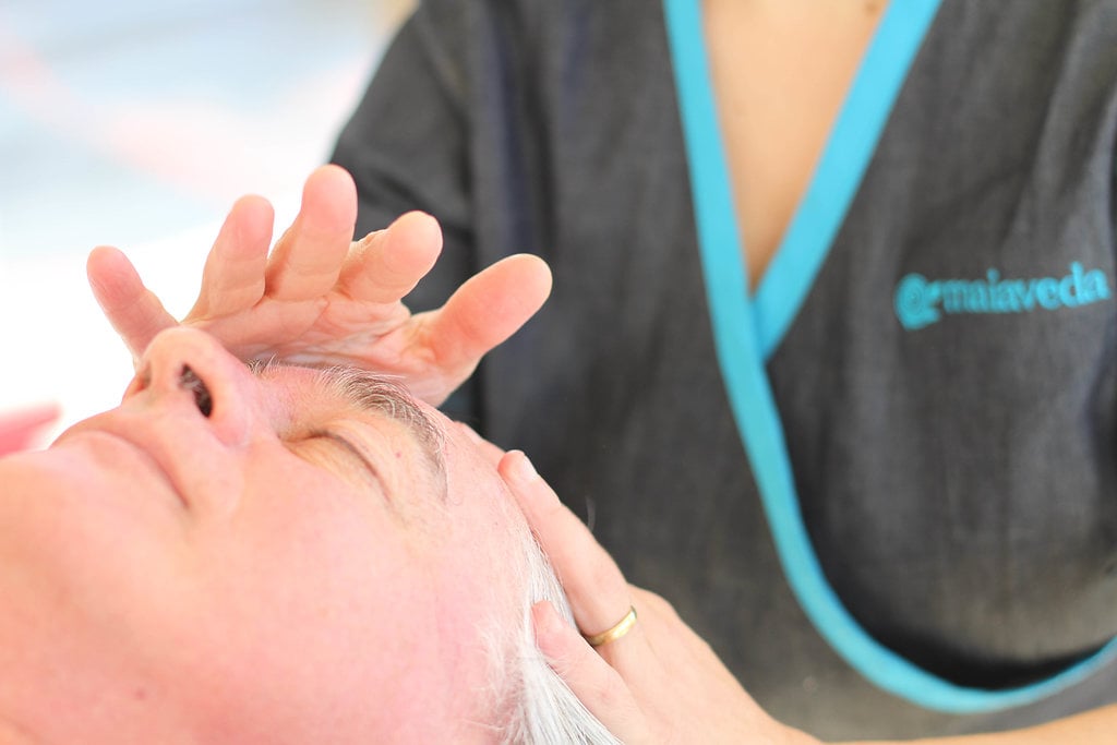 A therapist giving a face and head massage