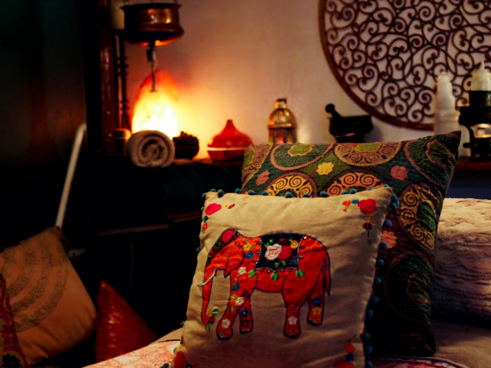 A treatment room at Maiaveda in lamplight, an elephant cushion on the bed