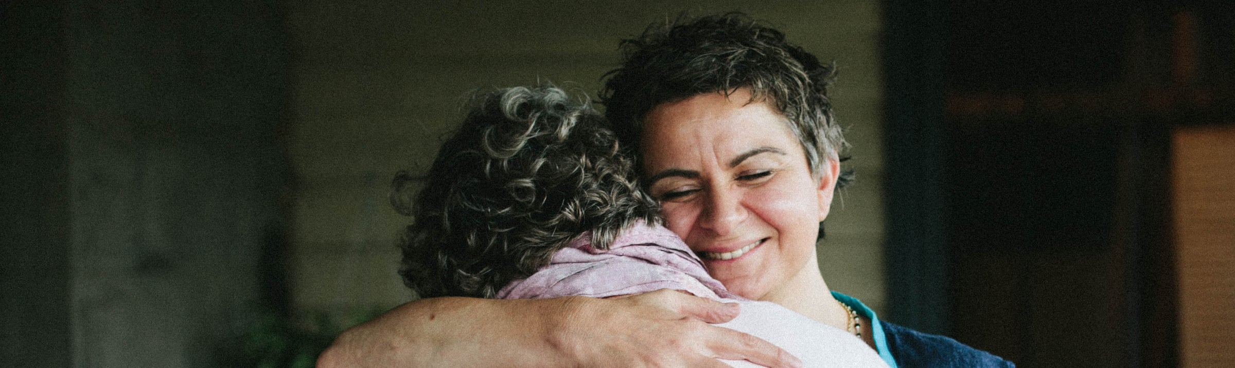 Marye O'Brien smiling as she embraces a guest