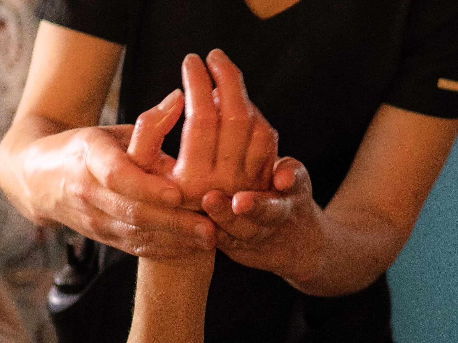 A therapist massaging a client's oiled hand