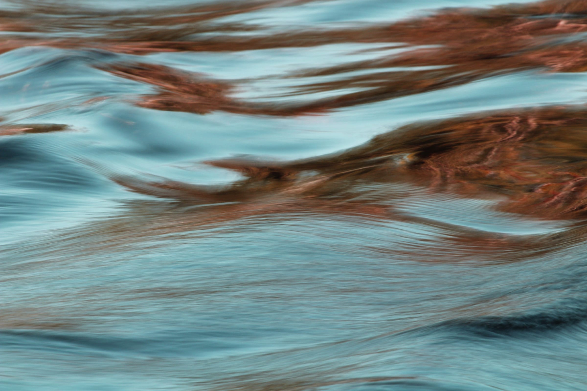 Water rippling over red-brown reflections
