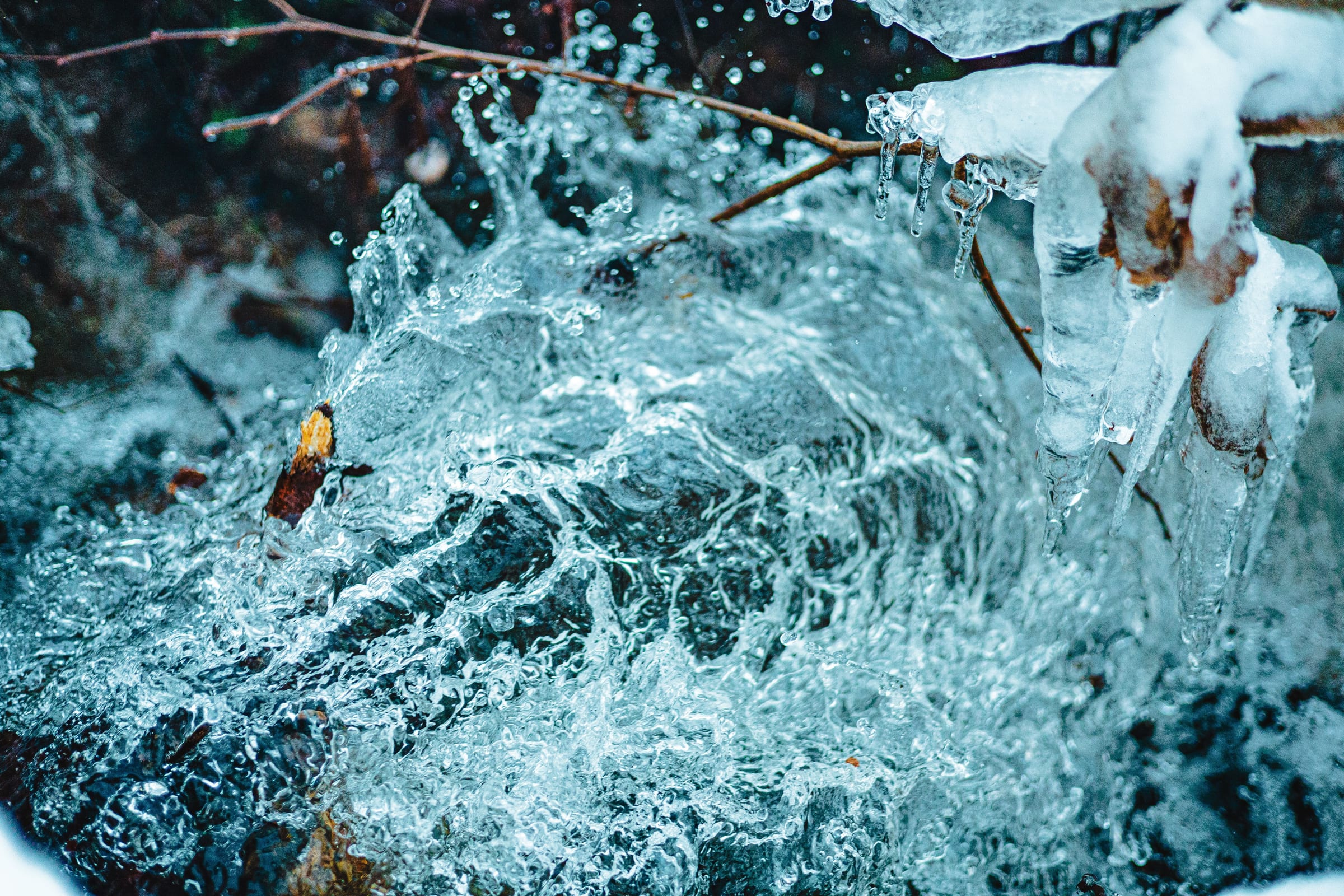 Clear water splashing over icy rocks