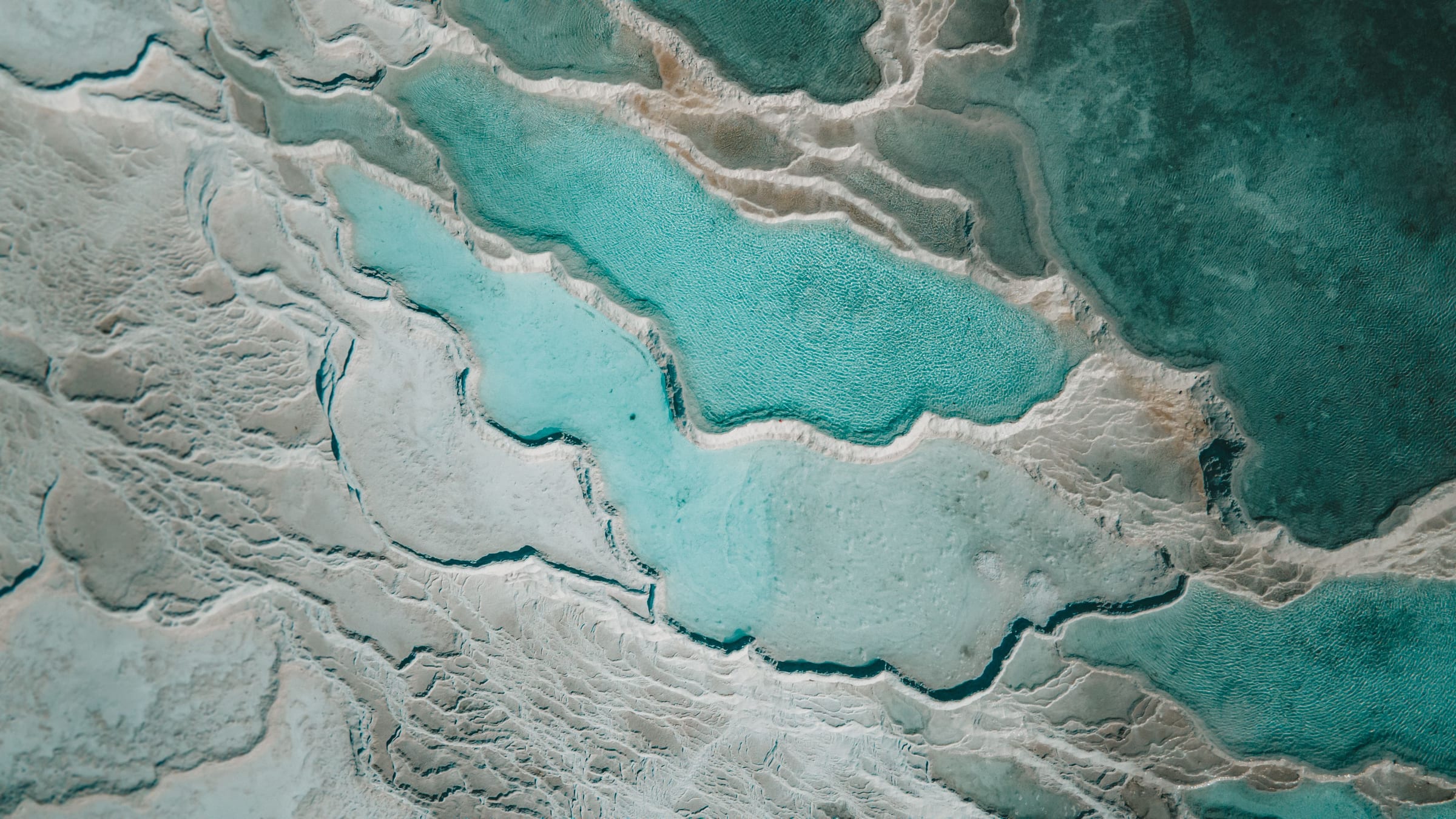 Turquoise pools in white travertine terraces